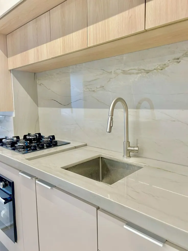 Cocina con cubierta y salpicadero en cuarcita blanca veteada
