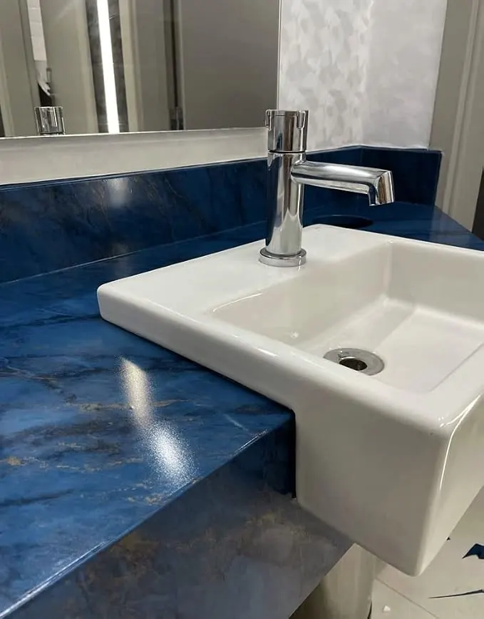Cubierta de baño en piedra azul con lavabo blanco
