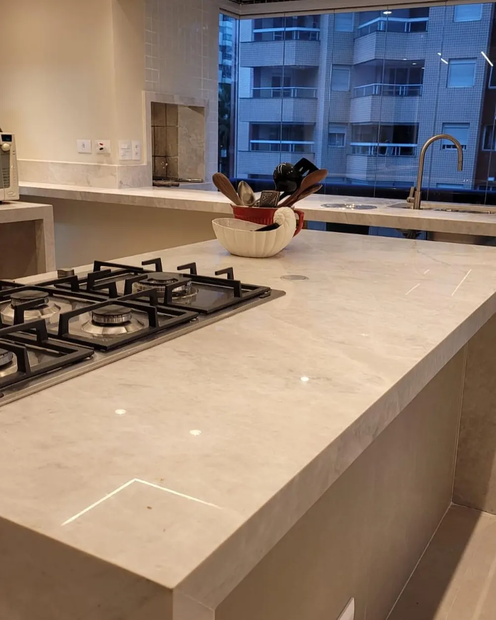 Isla de cocina en mármol blanco con parrilla integrada