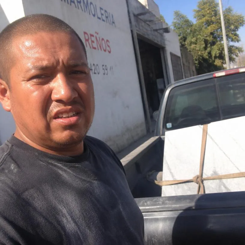 Marmolista usando el Pack Tesoro del Marmolista en su taller, con una camioneta cargada de placas de piedra