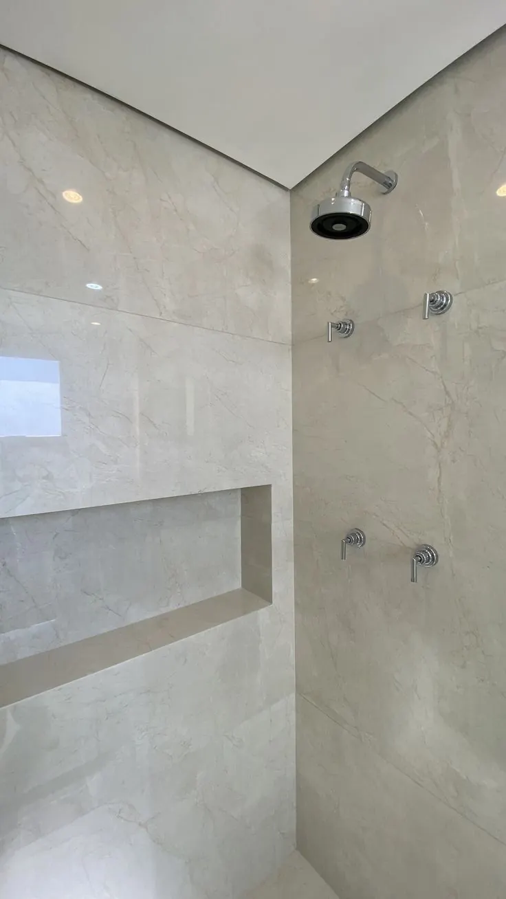 Ducha revestida en mármol beige con nicho integrado